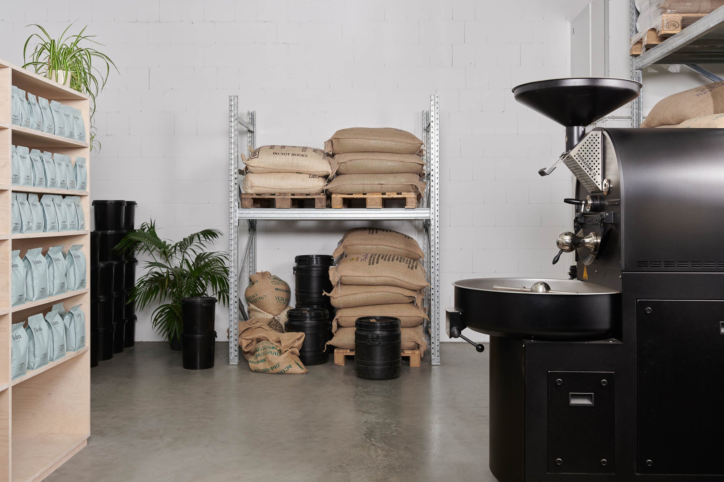 Die Kaffeerösterei mit Kaffeeregal, Rohkaffeeregal und Trommelröster am Kölner Stadtrand
